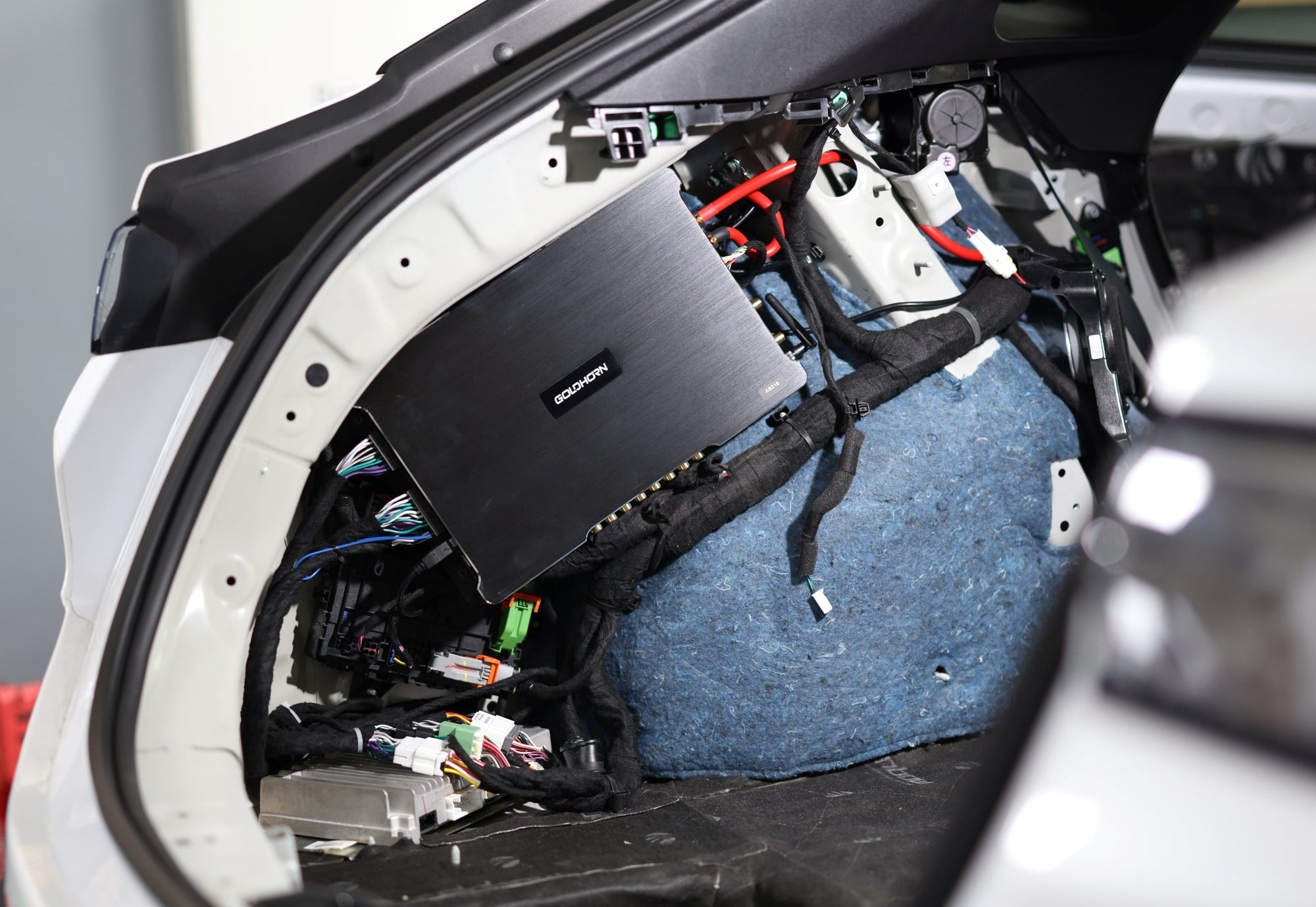 Car interior with open door showing mechanical components and wiring.