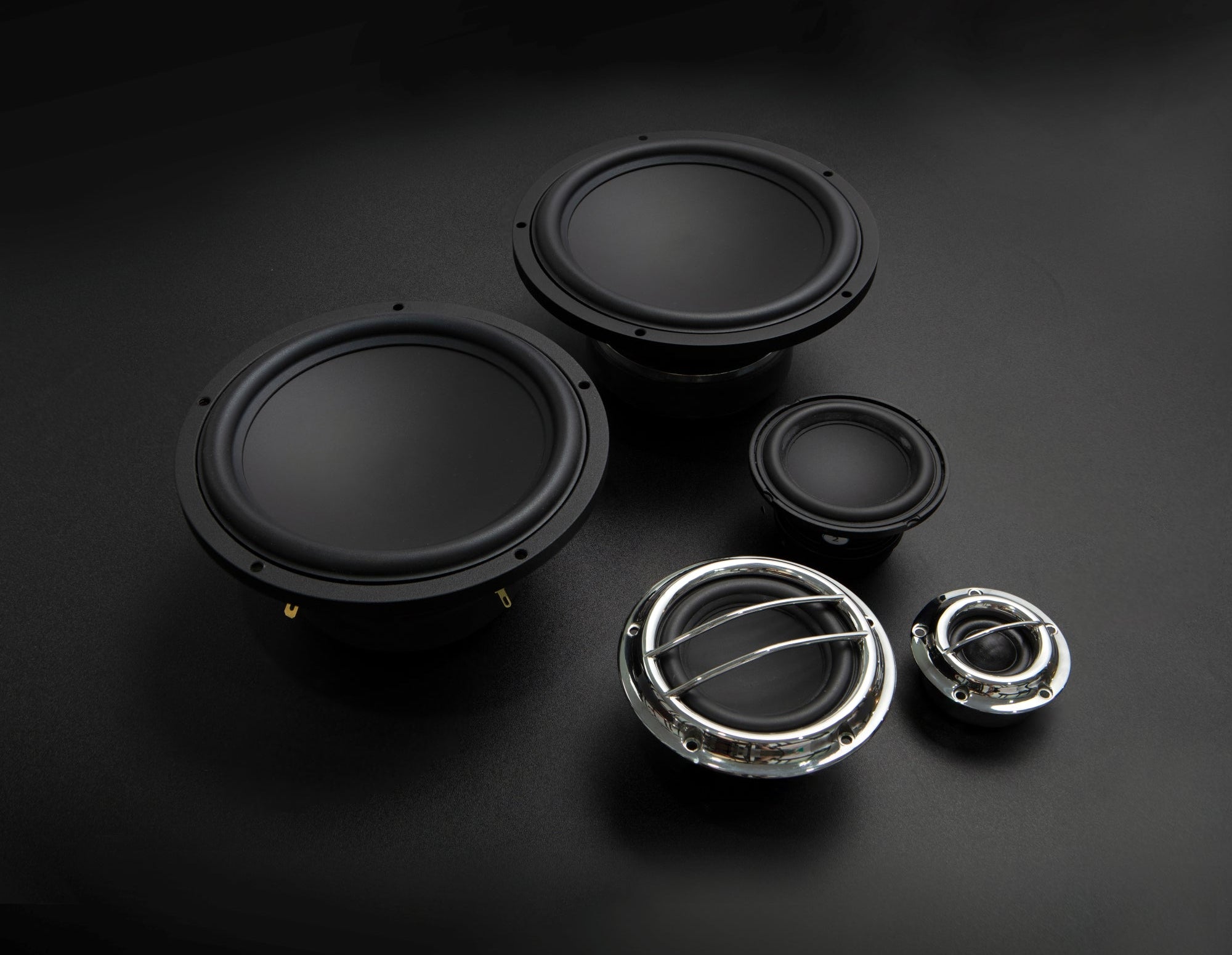 Set of black speakers and metal grilles on a dark background