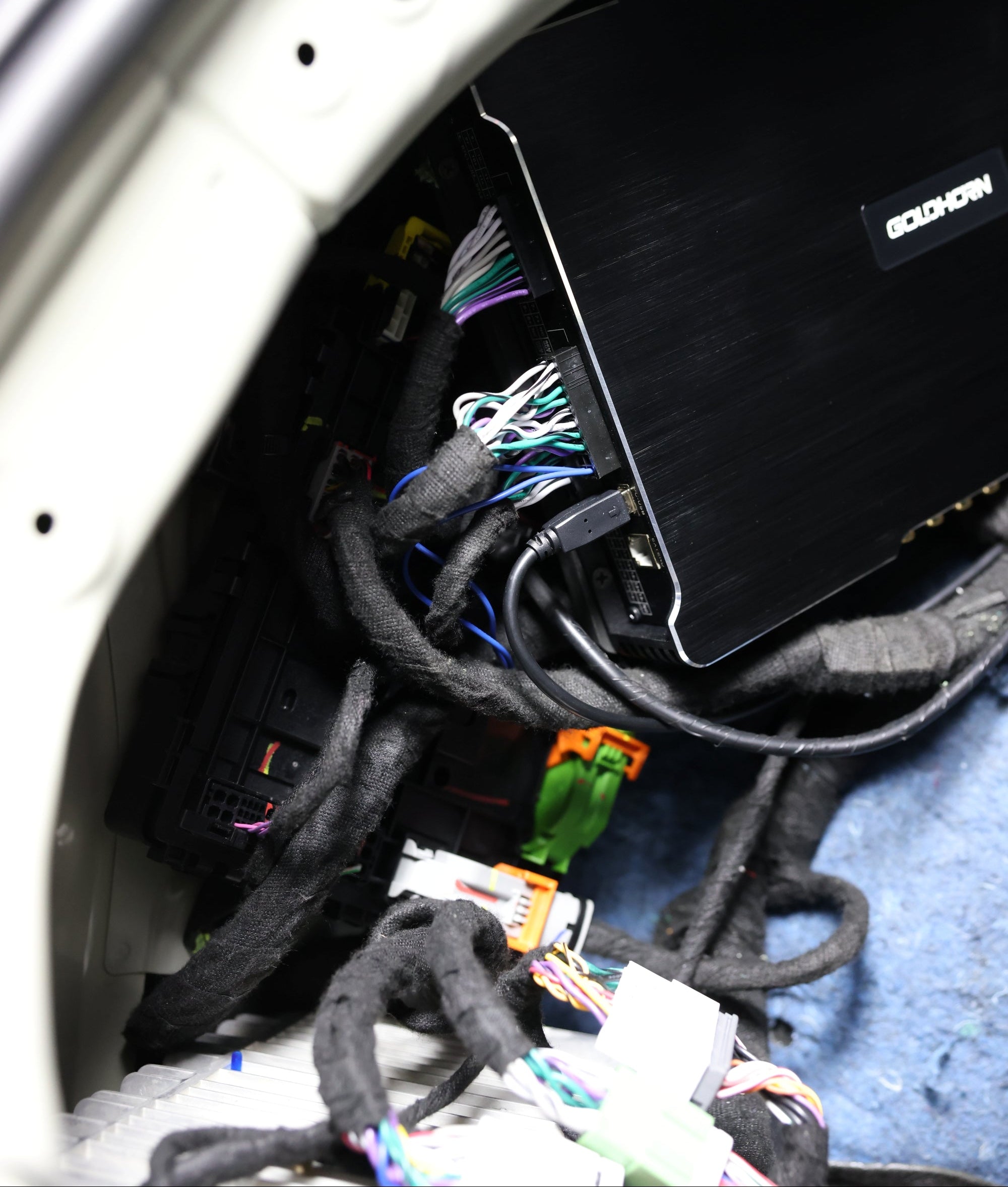 Car interior with audio system wiring and a subwoofer installed.